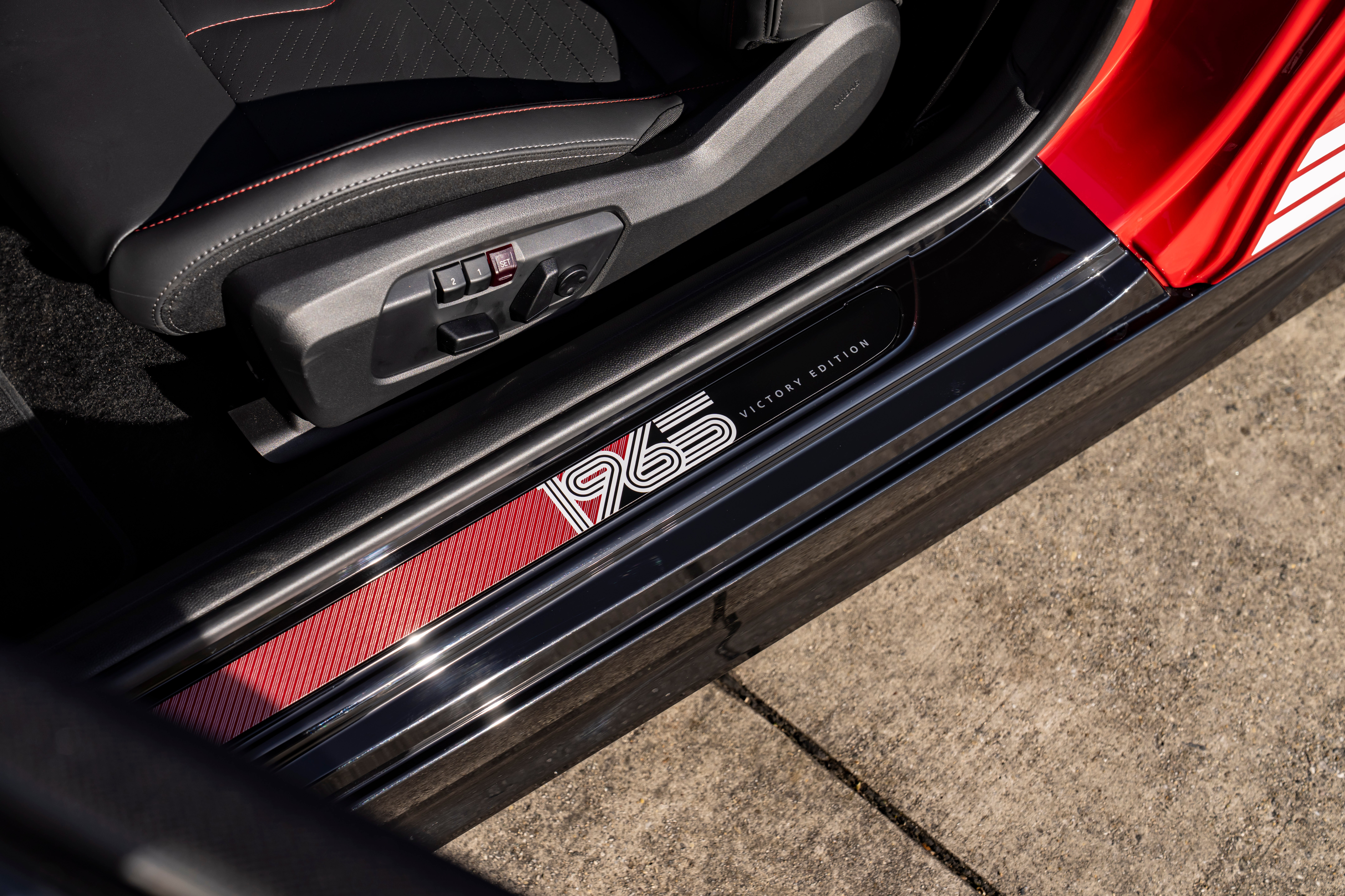 Soleira da porta do MINI Victory Edition com a inscrição “1965” em branco sobre um fundo vermelho e preto